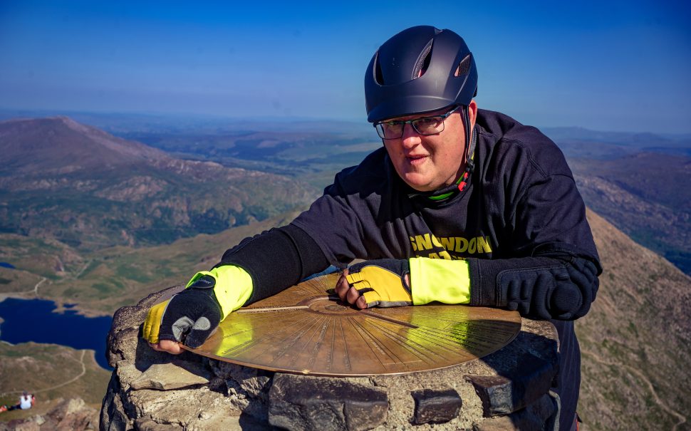 man standing at the top of a mountain