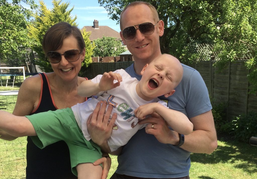 A photo of Jenny Houghton and her husband pictured with their son in the garden whilst he was having cancer treatment.