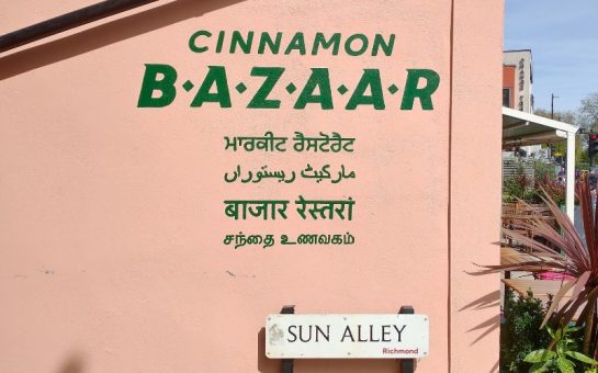 Pink painted side of restaurant with name Cinnamon Bazaar and Richmond street sign