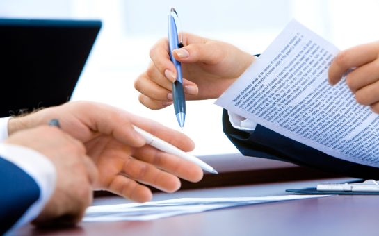 person holding a pen and job contract