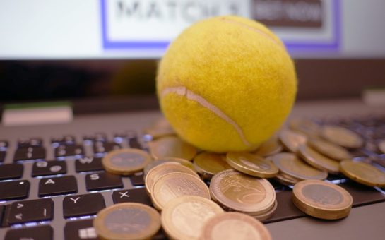 A tennis ball and coins on a computer keyboard