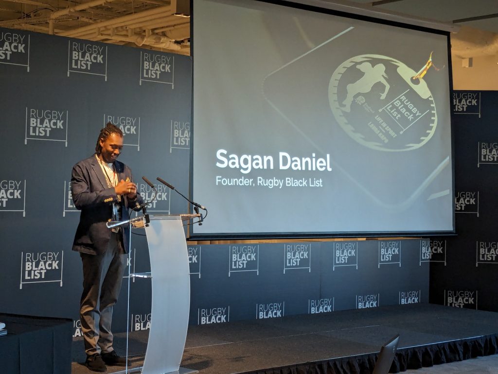 Sagan Daniels on stage behind a podium at the Rugby Black List Awards