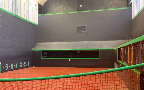 Hampton Court Palace's royal tennis court with the net in the foreground and the court's slanted roof in the background