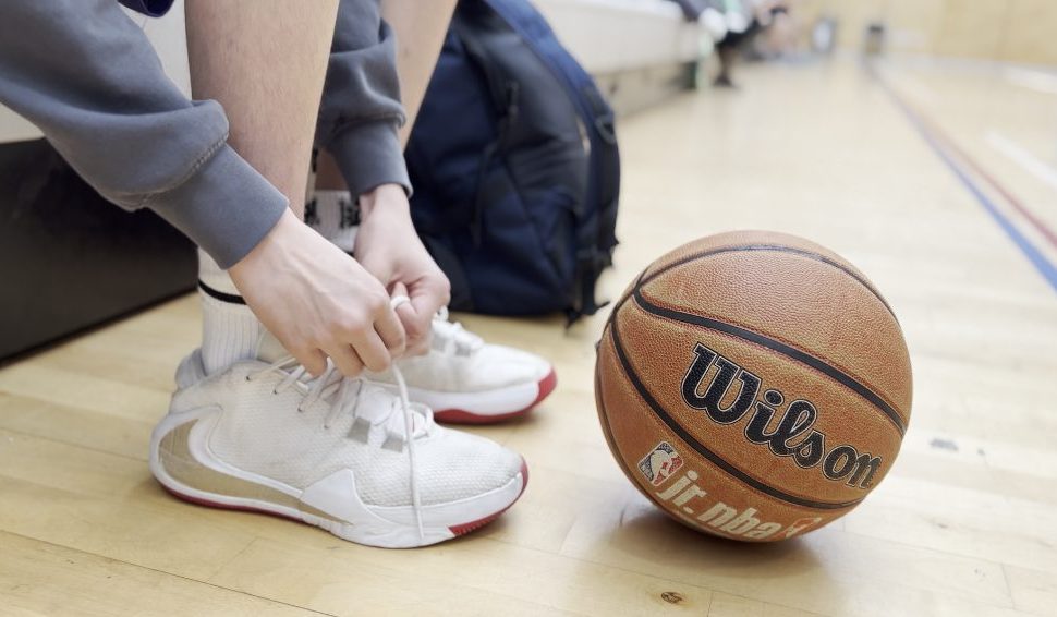 Basketball next to a child tying their trainers