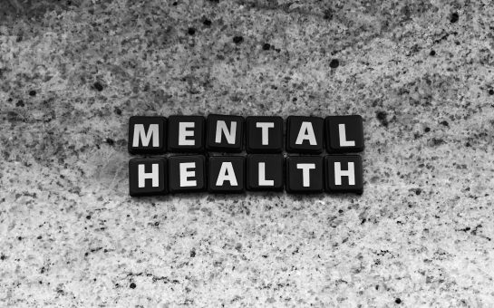 Scrabble pieces spelling out mental health on a marble grey background