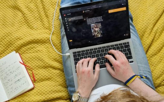 A person with a laptop on their lap, texting an AI girlfriend