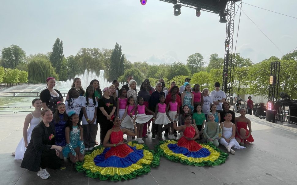 A dance group occupy the stage at Strictly Wandsworth, posing and smiling for the camera.