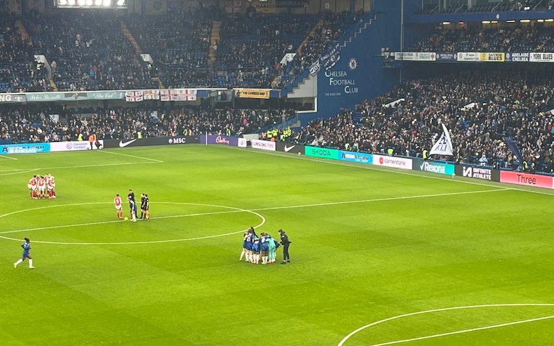 Chelsea and Arsenal players in pre-match huddles at Stamford Bridge before kick-off in a WSL match