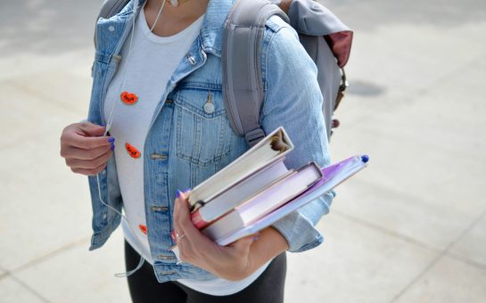 A student carrying books (Credit: Free to use from Unsplash)