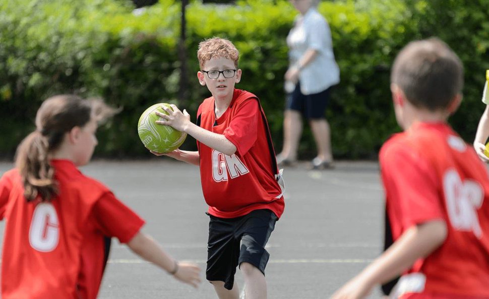Three children playing netball