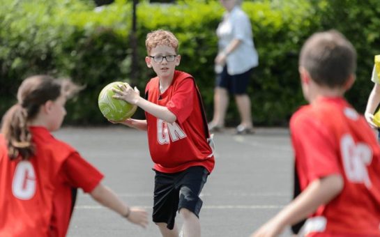 Three children playing netball