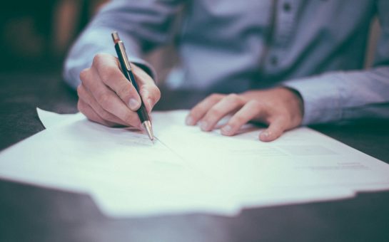 Man signing a document (Credit: Free to use from Unsplash)