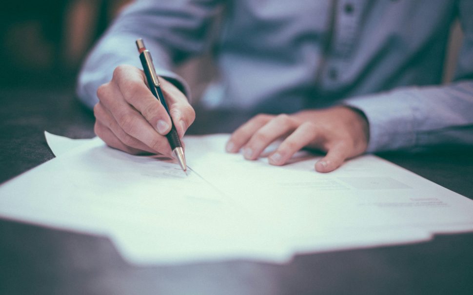 Man signing a document (Credit: Free to use from Unsplash)