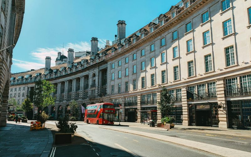 A photo of a red bus on Regent Street, Westminster on a summery day.