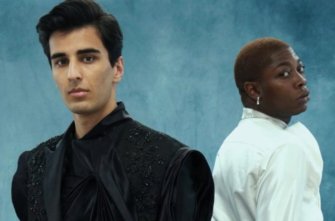 Two models wearing Spencer Thornton's graduate show collection on a blue textured backdrop.