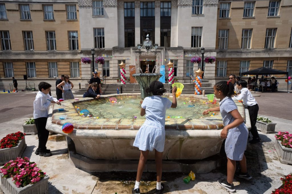Children play around a fountain