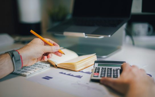Someone filling their tax return. Photo credit Jakub Żerdzicki on Unsplash.