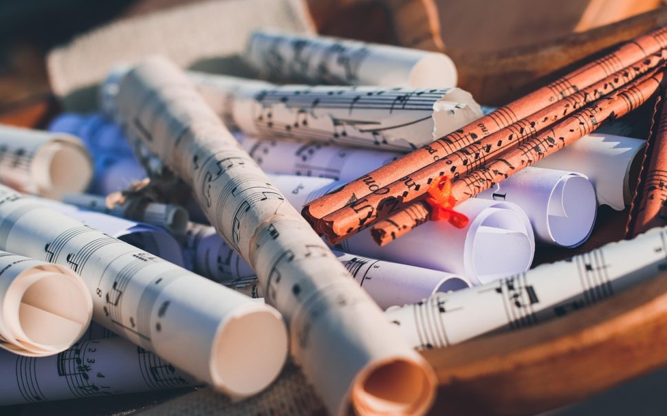 Sheets of paper with music on them rolled up on a table