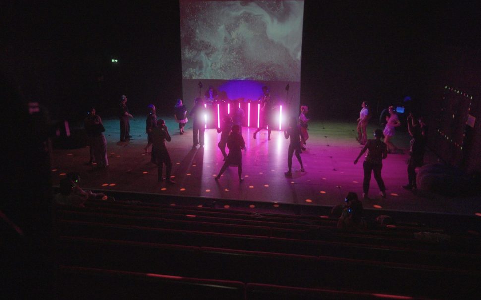 People dancing at a rave with purple lights