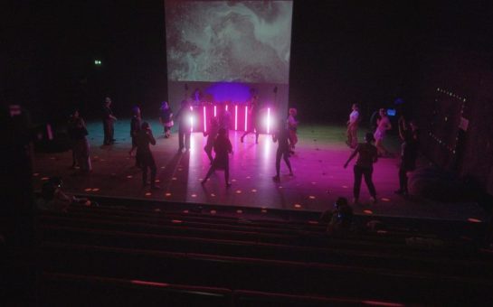 People dancing at a rave with purple lights