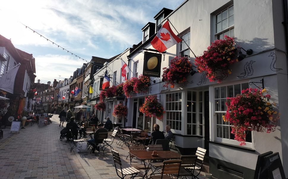 A pub on Church Lane, Twickenham, on a sunny day with flags flying from the building fronts for Women's Rugby World Cup Final