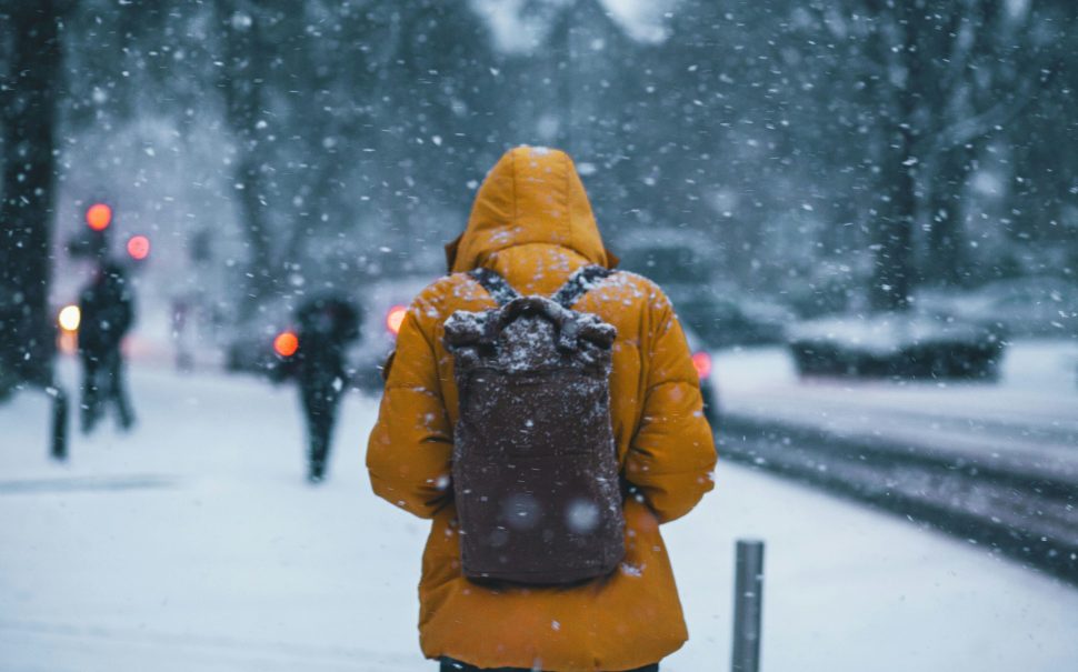 Person in a big coat walking in the snow (Credit: Free to use from Unsplash)