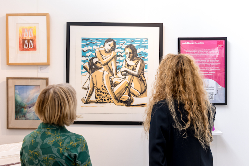 two women looking at a painting at the Affordable art fair in battersea
