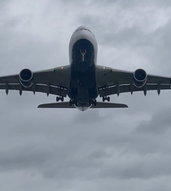 A large plane flying over Heathrow airport.