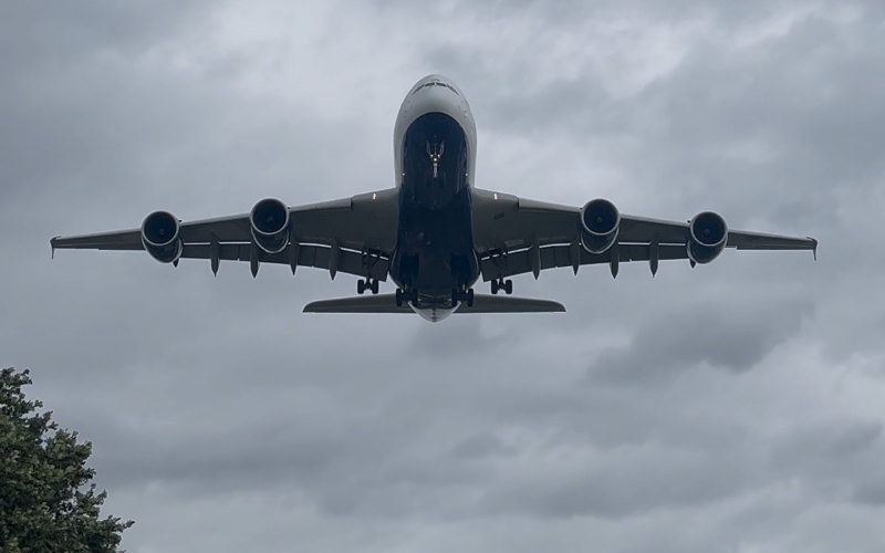 A large plane flying over Heathrow airport.