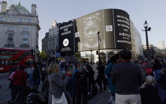 The Piccadilly Lights showing a black and white image of a young black girl with Down's Syndrome