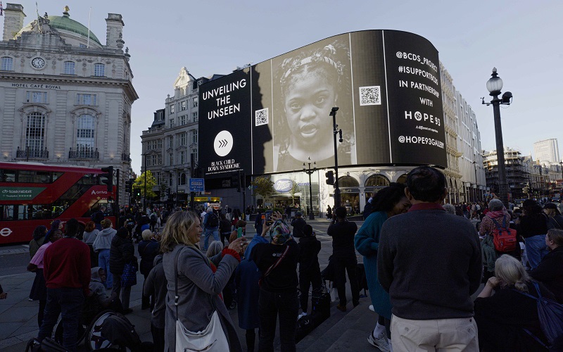 The Piccadilly Lights showing a black and white image of a young black girl with Down's Syndrome
