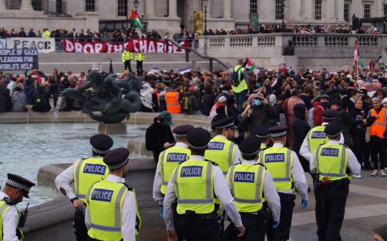 Police officers moving to arrest Palestine Action supporters in Trafalgar Square