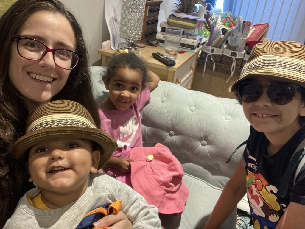 An image of Thea Jaffe, a working mother, with her three children sitting on a sofa in their home.