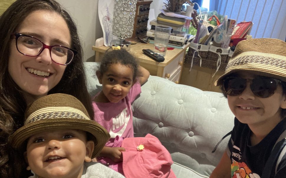An image of Thea Jaffe, a working mother, with her three children sitting on a sofa in their home.