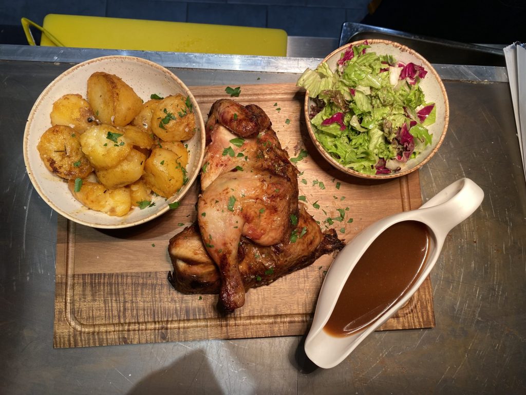 The rotisserie chicken meal, served with crispy potatoes, dressed salad and warming gravy.