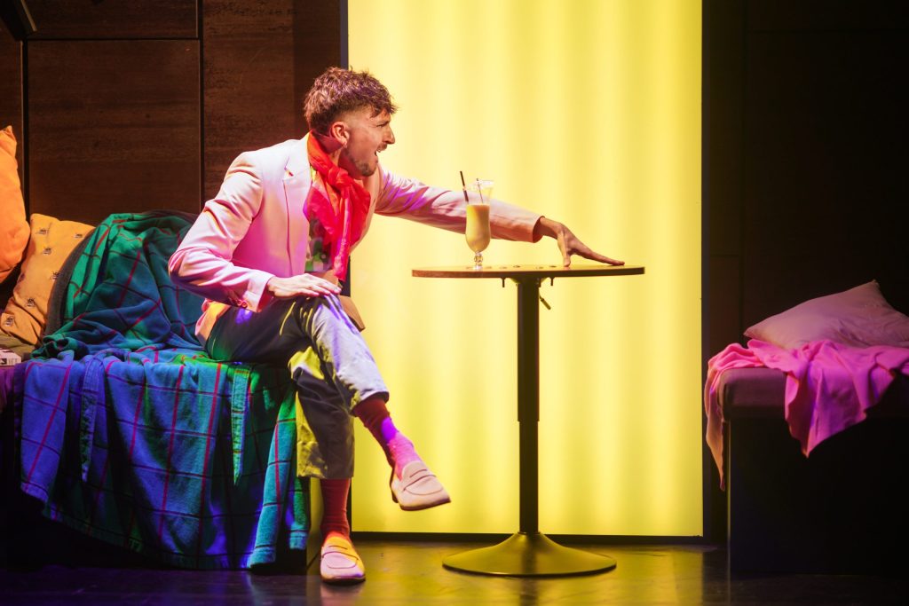A man sits at a table in the London musical Love Quirks