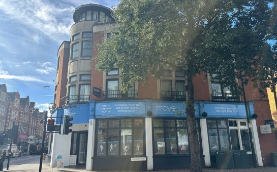 the front of Move Physio in Twickenham. One the corner of a road with a round front, big windows and a blue strap with the company name around the top.