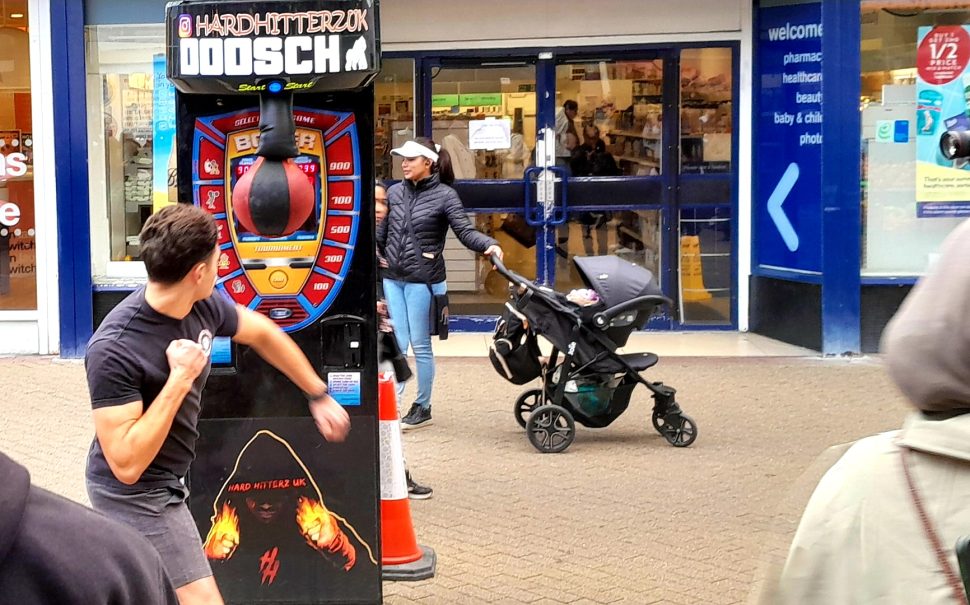 Man punching a boxing machine.