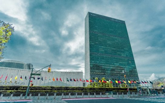 An image of the United Nations HQ in New York with multiple national flags. credit: Nils Huenerfuerst on Unsplash