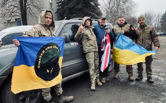 Adrian Simpson alongside Ukrainian troops holding British and Ukrainian Flags