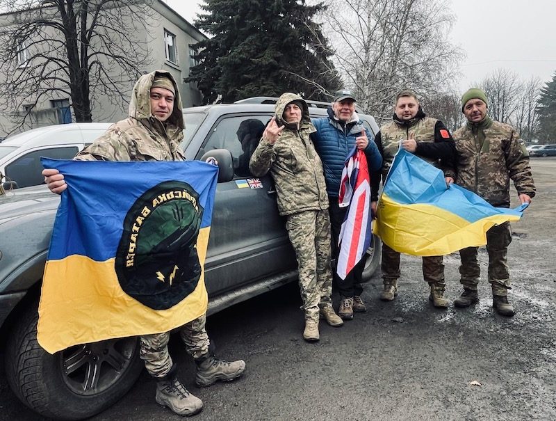 Adrian Simpson alongside Ukrainian troops holding British and Ukrainian Flags
