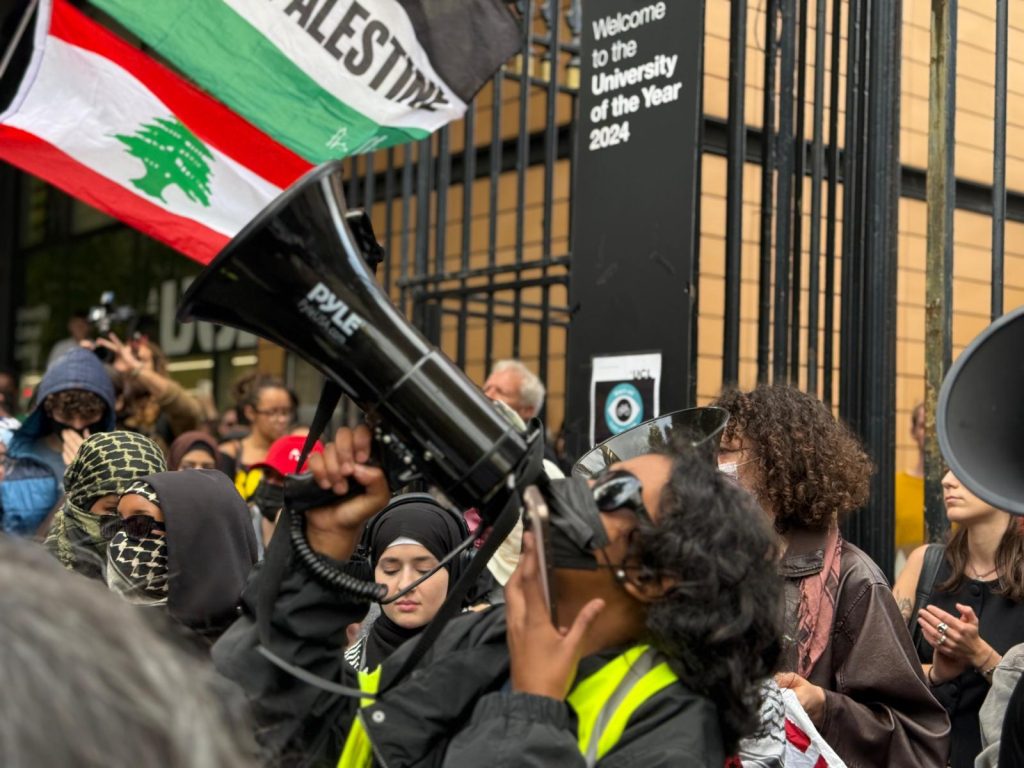 student speaks through a loud speaker at a Palestine protest