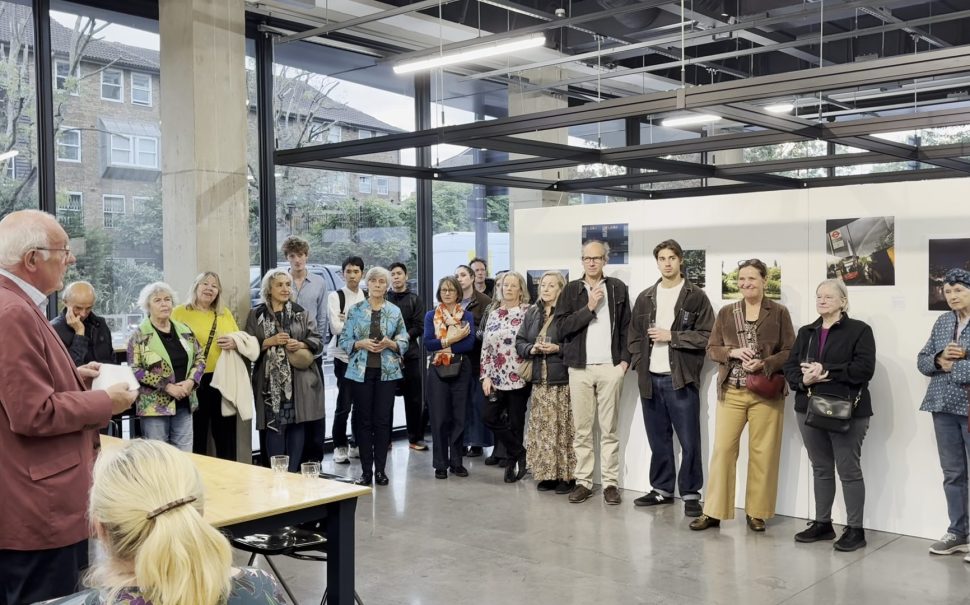 A crowd gathered in front of a photography exhibition for an awards ceremony.