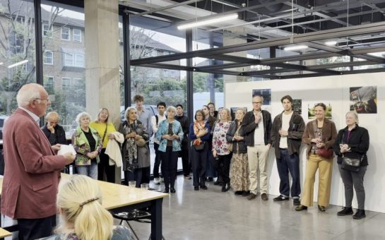A crowd gathered in front of a photography exhibition for an awards ceremony.