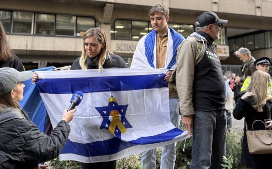 Woman holds up Israeli flag at pro-Palestine protest