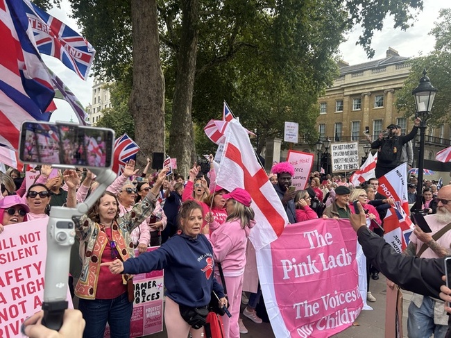 Protestors pictured at 'Pink Ladies' protest holding a pink sign that reads 'The Pink Ladies / The Voices of our Children'.