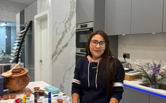 Woman in black hoodie standing at a paint station