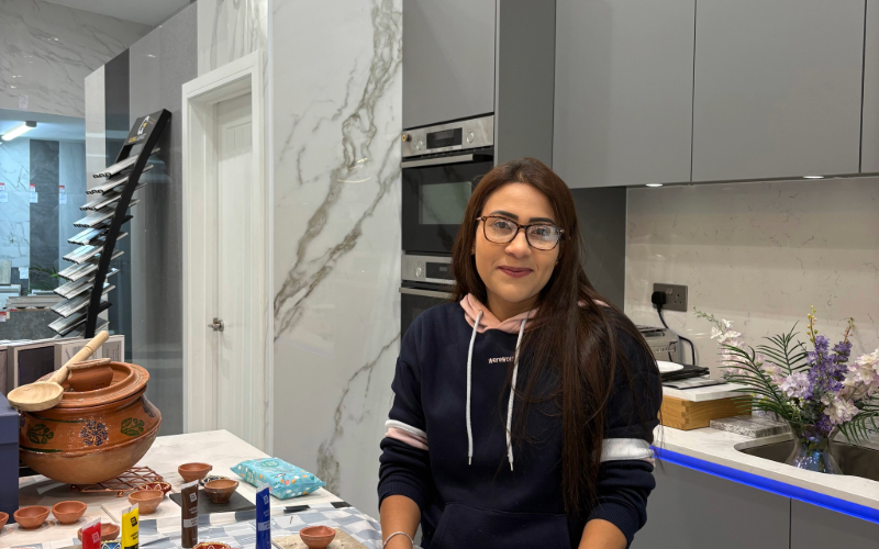 Woman in black hoodie standing at a paint station