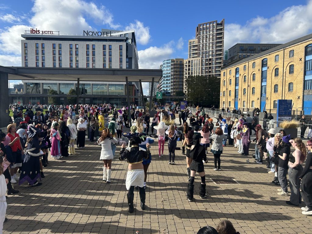 A group of young people dressed up dance in the circle to K-pop