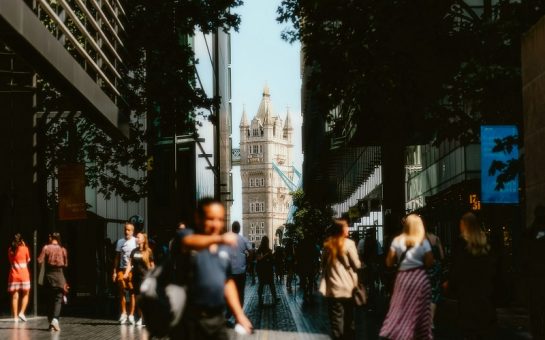 A picture of Tower bridge with crowds of people in the sunshine. Photo by Alin Gavriliuc on Unsplash